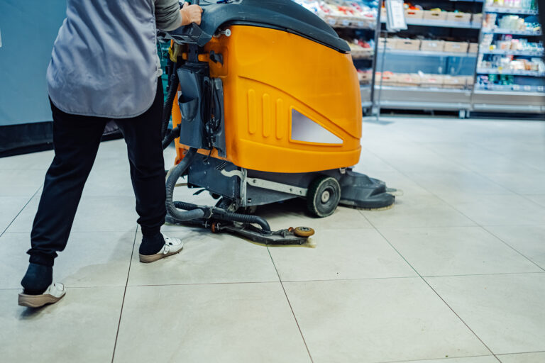 Bodenreinigungsmaschine wird durch Gang geführt.