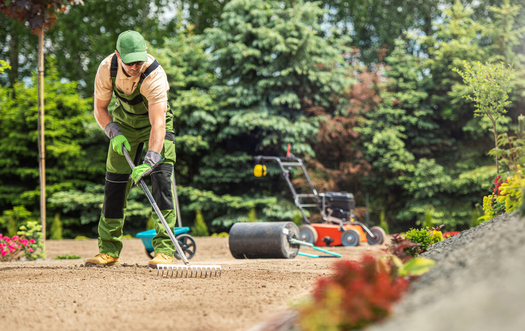 Gärtner arbeitet im Park und trägt Gartengeräte.