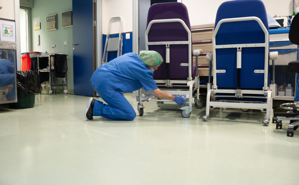 Reinigungspersonal säubert Krankenhaus Transport Geräte für Patienten.